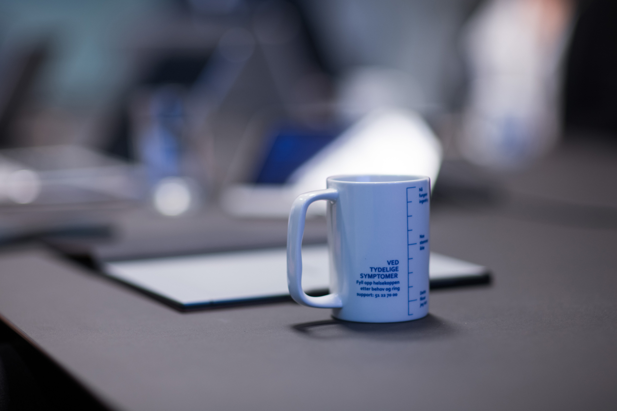 Bilde av Upheads kaffekopp i møterom.