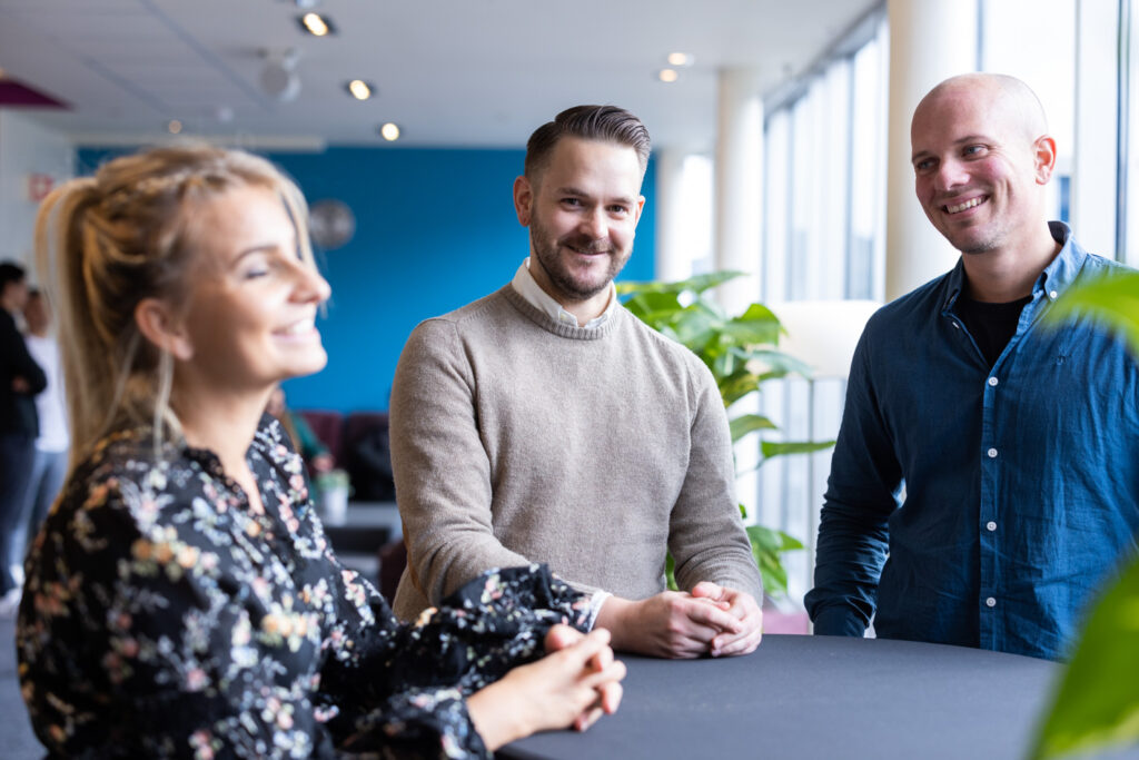 Tre smilende Upheads kollegaer